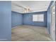 Bedroom with blue walls, carpet, ceiling fan, and window at 11386 W Buchanan St, Avondale, AZ 85323