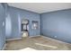 Living room with blue walls, neutral carpet, and view to another room at 11386 W Buchanan St, Avondale, AZ 85323