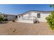 Gravel backyard with mature trees and a home exterior at 11596 W Sierra Dawn Blvd # 109, Surprise, AZ 85378