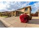 Two-story home with a three-car garage and red flowers at 13332 W Palo Verde Dr, Litchfield Park, AZ 85340