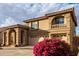 Two-story home with a three-car garage and red flowers at 13332 W Palo Verde Dr, Litchfield Park, AZ 85340