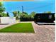 Landscaped backyard with artificial turf and storage buildings at 1539 E 3Rd St, Mesa, AZ 85203