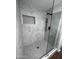 Walk-in shower with marble-style tile and a frameless glass enclosure at 1539 E 3Rd St, Mesa, AZ 85203