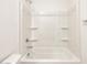 Bright bathroom features a white tub/shower combo with built in shelving at 16029 W Desert Hollow Dr, Surprise, AZ 85387