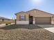 Inviting single-story home showcases a desert landscape, neutral stucco, and a two-car garage at 16029 W Desert Hollow Dr, Surprise, AZ 85387