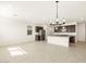 Open living space with modern lighting, kitchen island, and tile floors at 16029 W Desert Hollow Dr, Surprise, AZ 85387