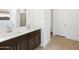 Bright bathroom featuring double sinks, white countertops, and tile floors at 16074 W Prickly Pear Trl, Surprise, AZ 85387