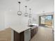 Modern kitchen island with stainless steel appliances, farmhouse sink, and stylish pendant lighting at 16074 W Prickly Pear Trl, Surprise, AZ 85387