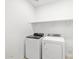 A modern laundry room features a new washer and dryer with a convenient shelf above for storage at 16074 W Prickly Pear Trl, Surprise, AZ 85387