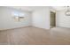 Bright living room with wood-look tile flooring and sliding glass doors at 16074 W Prickly Pear Trl, Surprise, AZ 85387