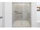 Modern shower features glass doors and tiled walls in a bright and airy bathroom at 16074 W Prickly Pear Trl, Surprise, AZ 85387