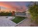 Sunset view of backyard with playground, trampoline, fire pit, and artificial turf at 17152 W Grant St, Goodyear, AZ 85338