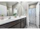 Double vanity bathroom with a colorful shower curtain at 17152 W Grant St, Goodyear, AZ 85338