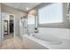 Relaxing bathroom with soaking tub, glass shower, and modern fixtures at 17152 W Grant St, Goodyear, AZ 85338