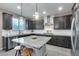 Spacious kitchen featuring granite island, dark cabinetry, and herringbone backsplash at 17152 W Grant St, Goodyear, AZ 85338