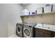 Laundry room with washer, dryer, utility sink, and shelving at 17152 W Grant St, Goodyear, AZ 85338