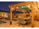 Outdoor dining and lounge area under a charming pergola with lighting at 19930 W Exeter Blvd, Litchfield Park, AZ 85340