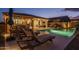 Luxury pool and patio area with lounge chairs and string lights at 19930 W Exeter Blvd, Litchfield Park, AZ 85340