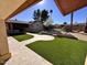 Landscaped backyard with artificial turf and stone pathways at 215 E Marconi Ave, Phoenix, AZ 85022