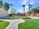 Landscaped backyard with artificial turf, stone pathways, and mature palm trees at 215 E Marconi Ave, Phoenix, AZ 85022