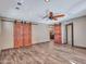 Spacious bedroom with barn doors and wood-look tile flooring at 215 E Marconi Ave, Phoenix, AZ 85022