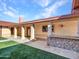 Outdoor patio with stonework, covered area, and adjacent grassy area at 215 E Marconi Ave, Phoenix, AZ 85022