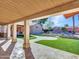 Covered patio overlooking backyard with artificial turf and landscaping at 215 E Marconi Ave, Phoenix, AZ 85022