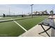 Artificial turf bocce ball court with benches and playground in background at 22827 E Lords Way, Queen Creek, AZ 85142