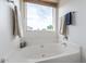 Relaxing bathroom featuring a large garden tub and bright window at 30084 N Desert Willow Blvd, San Tan Valley, AZ 85143