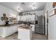 Open kitchen with white cabinets, island, and stainless steel appliances at 30084 N Desert Willow Blvd, San Tan Valley, AZ 85143