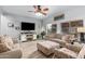 Living room with hardwood floors, comfortable seating, and a large TV at 30084 N Desert Willow Blvd, San Tan Valley, AZ 85143