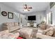 Living room with hardwood floors, comfortable seating, and a large TV at 30084 N Desert Willow Blvd, San Tan Valley, AZ 85143