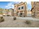 Tan three-story townhome with stone accents and a two-car garage at 3039 W Sand Flower Dr, Phoenix, AZ 85086