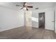 Bright bedroom features neutral walls, ceiling fan, wood-look floors, and an entrance to another room at 4044 E Oakland St, Gilbert, AZ 85295