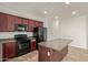 Modern kitchen with dark wood cabinets, black appliances, and an island at 4044 E Oakland St, Gilbert, AZ 85295