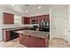 Modern kitchen with dark wood cabinets, black appliances, and an island at 4044 E Oakland St, Gilbert, AZ 85295