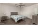 Neutral bedroom featuring a ceiling fan, wood-look floors and a light wood bedframe with a grey upholstered headboard at 4124 N 105Th Ln, Phoenix, AZ 85037