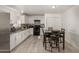 Bright and open kitchen featuring white cabinets, black appliances, and a view of the dining area at 4124 N 105Th Ln, Phoenix, AZ 85037