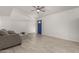 Bright living room featuring tile floors, neutral paint, ceiling fan, and blue front door at 4124 N 105Th Ln, Phoenix, AZ 85037