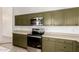 View of kitchen with olive green cabinets and stainless steel appliances at 4322 E South Fork Dr, Phoenix, AZ 85044