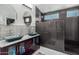 Modern bathroom with double sinks, dark tile, and a large shower at 45579 W Rainbow Dr, Maricopa, AZ 85139