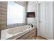 Bathroom featuring a large soaking tub and a window with blinds at 5432 W Fallen Leaf Ln, Glendale, AZ 85310