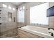 Elegant bathroom with soaking tub, walk-in shower, and modern fixtures at 5432 W Fallen Leaf Ln, Glendale, AZ 85310