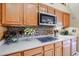 Kitchen with sleek cooktop, microwave, and wood cabinetry at 5432 W Fallen Leaf Ln, Glendale, AZ 85310