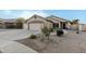 Two-car garage, desert landscaping, and neutral exterior at 6910 S 26Th Ln, Phoenix, AZ 85041