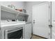 Laundry room with washer, dryer, and shelving at 6910 S 26Th Ln, Phoenix, AZ 85041