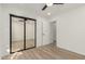 Light bedroom with wood floors and mirrored closet doors at 7489 E Windrose Dr, Scottsdale, AZ 85260