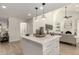 Modern kitchen island with white cabinets and a view into the living room at 7489 E Windrose Dr, Scottsdale, AZ 85260