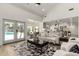 Living area with hardwood floors, white walls, and glass doors leading to the pool area at 7489 E Windrose Dr, Scottsdale, AZ 85260