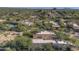 Aerial view of luxury home with tile roof and pool, nestled in a desert golf course community at 7546 E High Point Dr, Scottsdale, AZ 85266